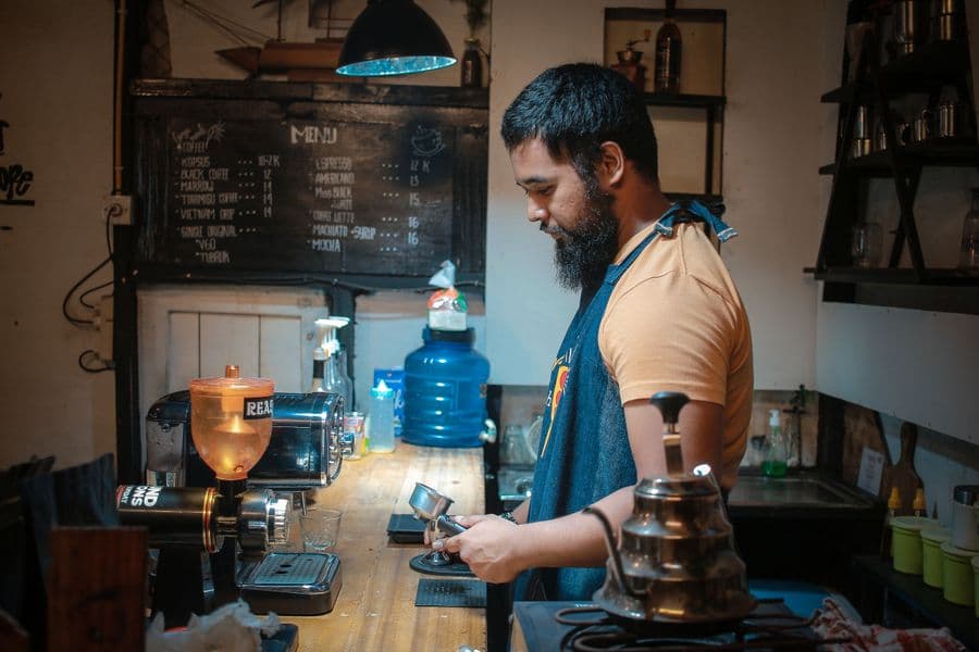 A barista at work behind a café counter
